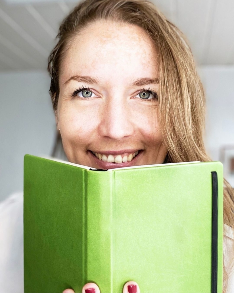 Svenja Hirsch mit einem grünen Buch in der Hand, weißer Hintergrund. Buchcoach, Buchcoachin, Co-Autorin, Selfpublishing